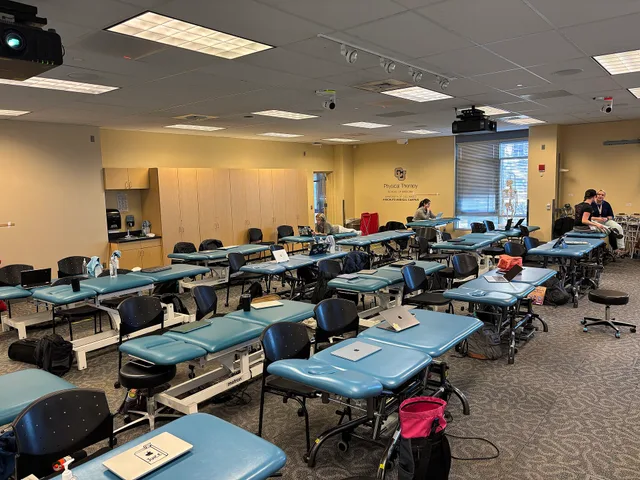 This image shows the Physical Therapy classroom at the University of Colorado Anschutz in 2025. The room contains multiple treatment tables, chairs, anatomical models, laptops, and educational supplies, illustrating a hands-on clinical learning environment for Doctor of Physical Therapy students. Th. Physical Therapy Local SEO Checklist for Clinics