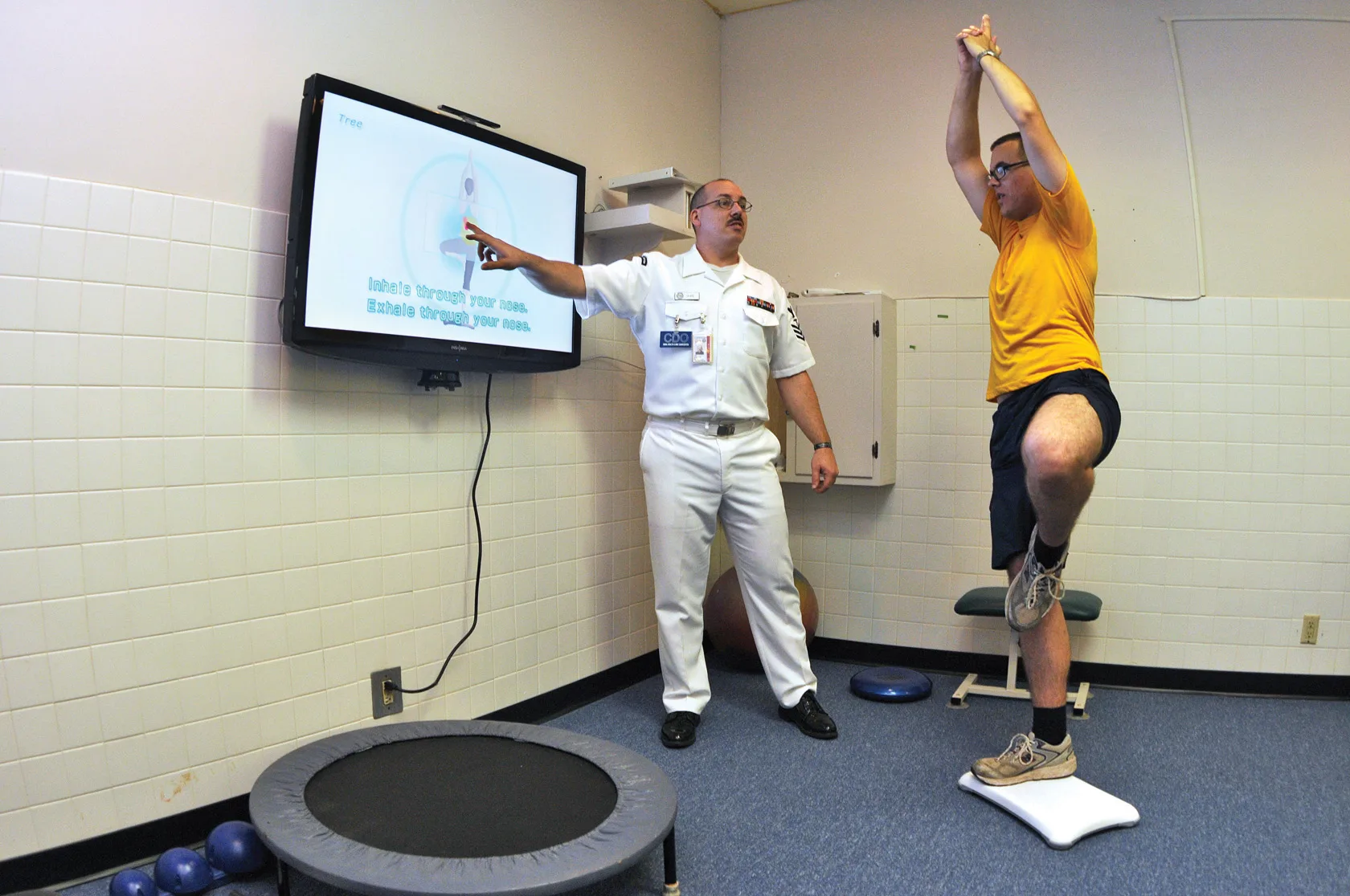 CHARLESTON, S.C. (July 2, 2009) Hospital Corpsman 1st Class Guy Duke, left, and Electronics Technician 3rd Class Joshua Benedict demonstrate how the Physical therapy Department at Naval Health Clinic, Charleston use the Wii Fitís yoga program as a therapy tool for patients. (U.S. Navy photo by Machi. Physical therapy expansion: trigger, six moves and a staged sequence